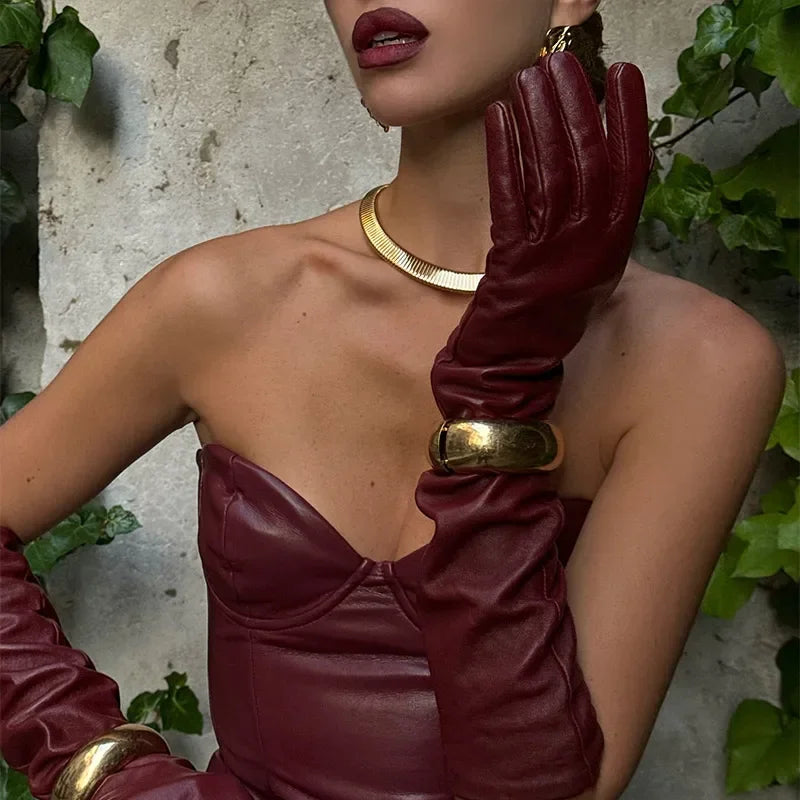 a woman wearing a red a-line, angkle-length dress with feather detailing and spaghetti straps  